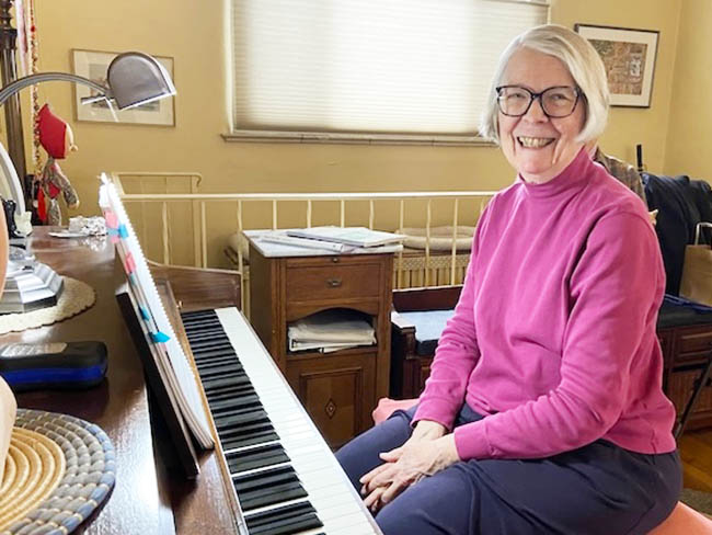 smiling woman seated at piano