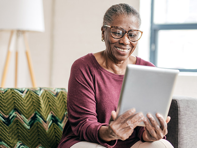 smiling woman looking at computer tablet